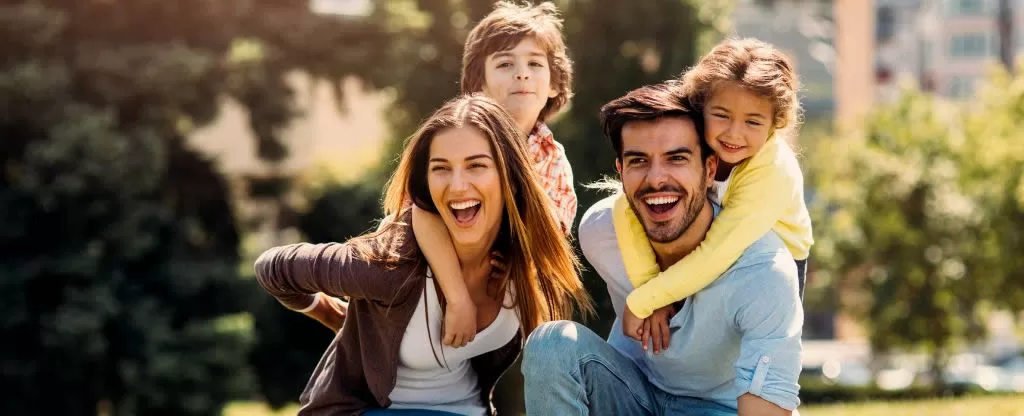 Pais sorrindo com os filhos em parque