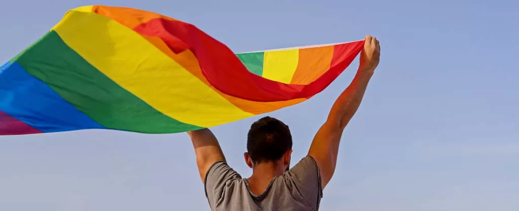 Homem segurando bandeira LGBT
