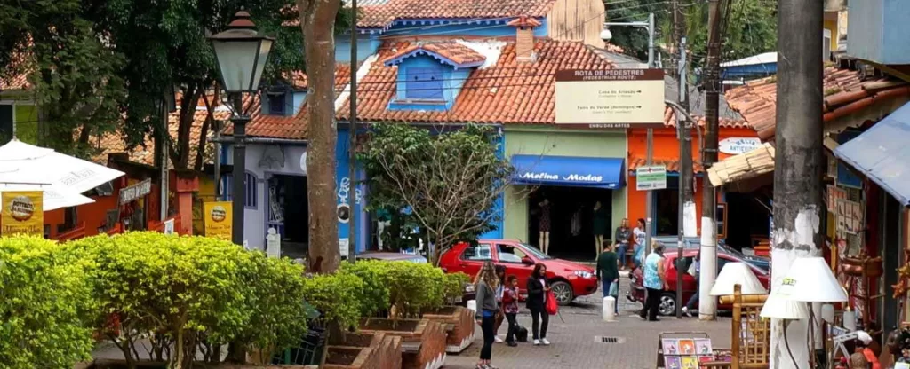 Embu das Artes (SP) Ladeira com árvores à esquerda e lojinhas de artesanato à direita.