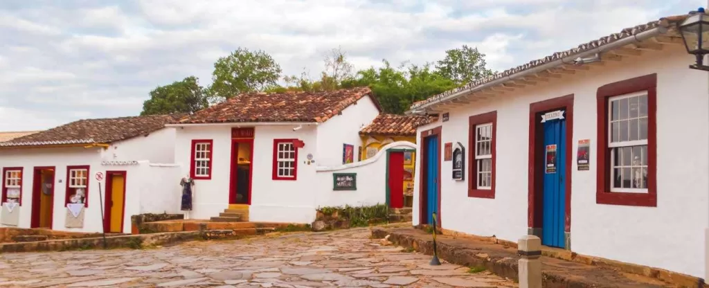 Ruas de pedra com casas antigas e nuvens ao fundo.