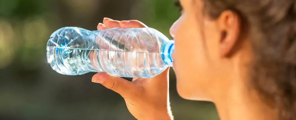 Mulher bebendo água em garrafa Mulher bebendo água em garrafa
