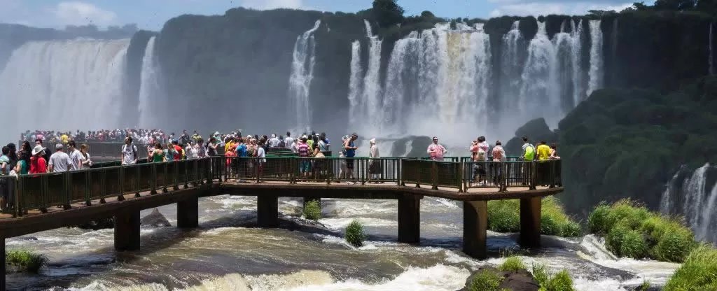 Passarela com muitas pessoas admirando ao fundo as Cataratas do Iguaçu Trilhas acessíveis Cataratas do Iguaçu