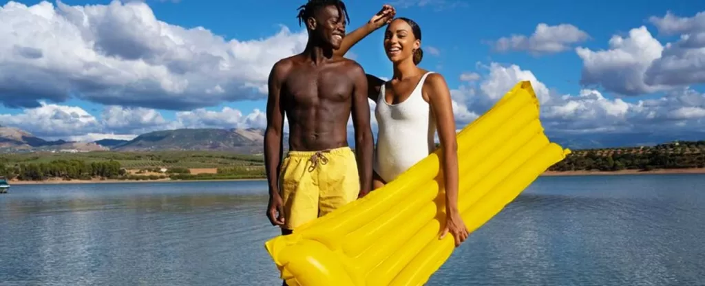Escolha uma data perfeita para ambos Casal negro em um lago segurando uma boia.