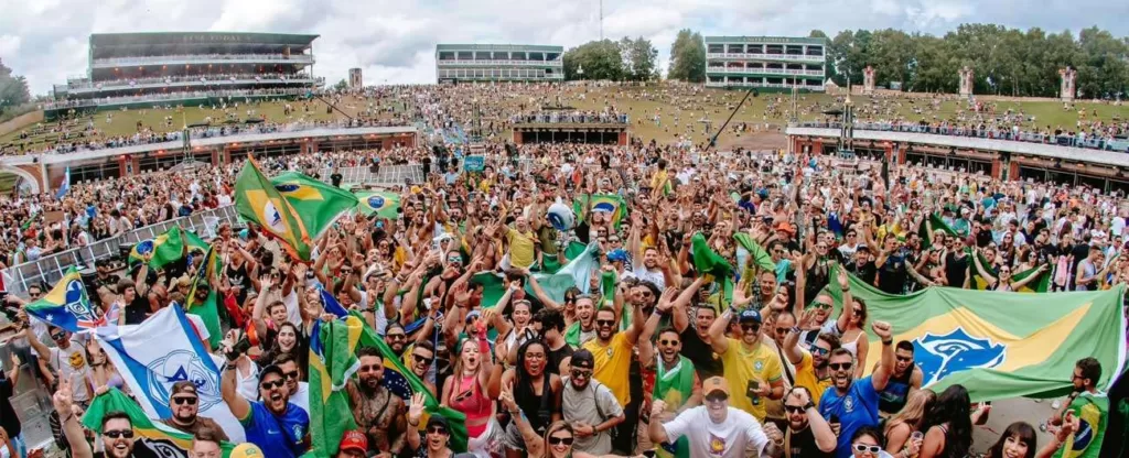 Como ir para o Tomorrowland Brasil de ônibus Multidão em um estival segurando várias bandeiras do Brasil.