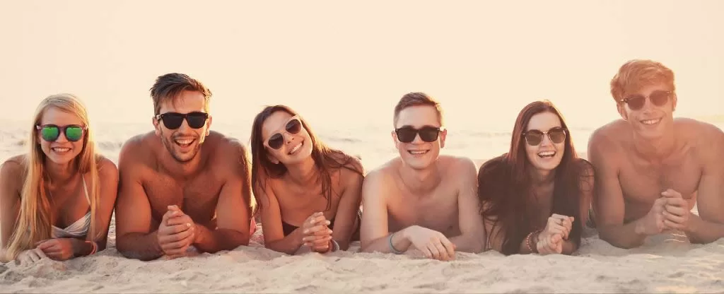 Grupo de amigos deitados na areia Grupo de amigos deitados na areia