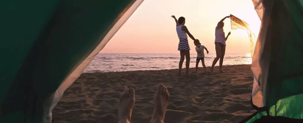 Pessoas acampando em praia 