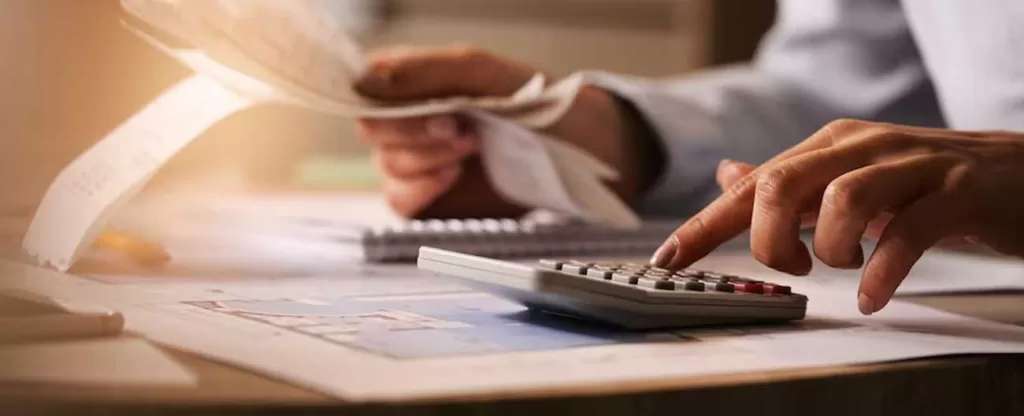 Determine um orçamento Mulher segurando papéis e usando uma calculadora.