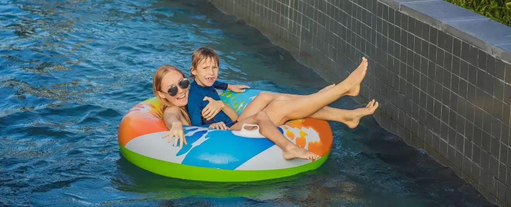 Menino e menina flutuando em boia em uma piscina Menino e menina flutuando em boia em uma piscina