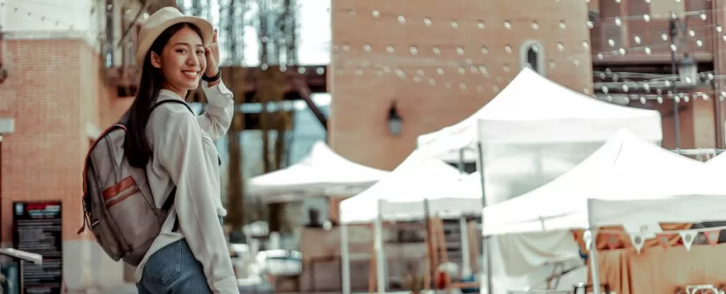 Mulher com mochila e chapéu sorrindo para foto Mulher com mochila e chapéu sorrindo para foto