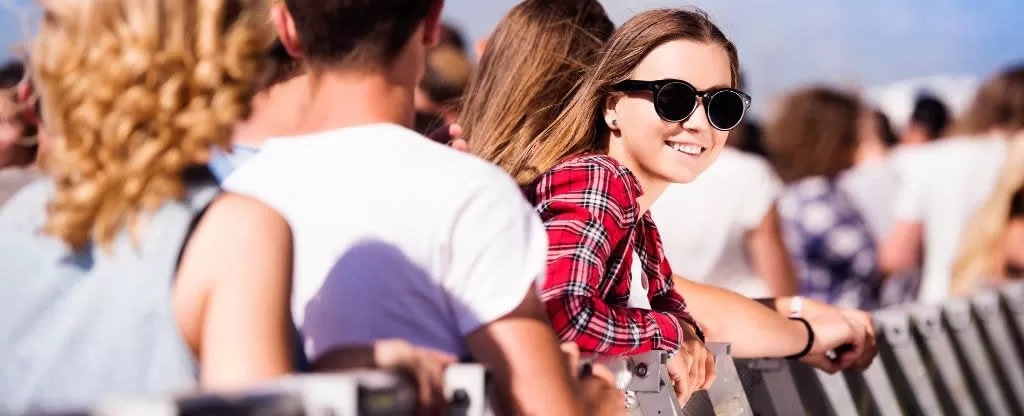 Mulher com óculos de sol preto sorrindo para foto Mulher com óculos de sol preto sorrindo para foto em festival