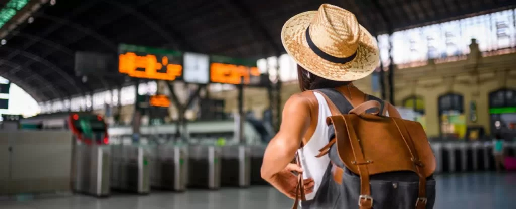 Mulher em pé de costas em uma rodoviária