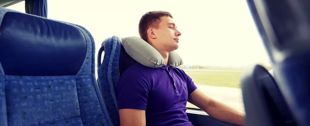 Homem dormindo em ônibus de viagem