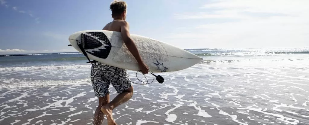 Homem segurando prancha de surf