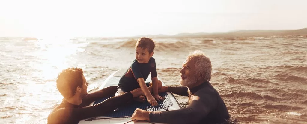 Homens ensinando criança a surfar - Trip Surf