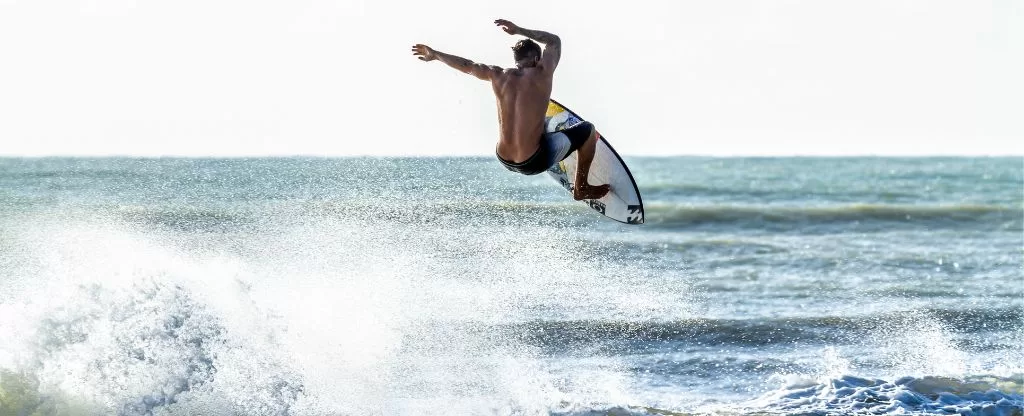 Pessoa surfando em mar Pessoa surfando em mar